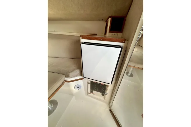 Slide: The Image of Interior of 2001 Contender 35 Side Console boat with compact fridge and seating area. - 15