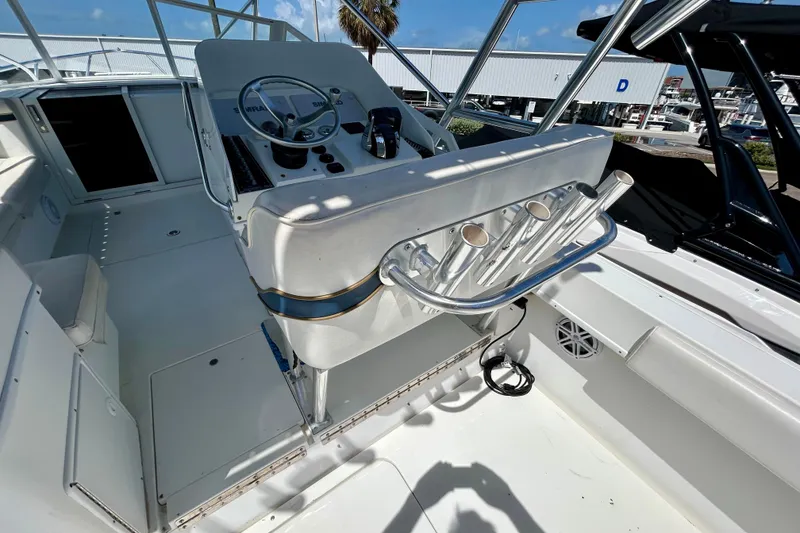 Slide: The Image of 2001 Contender 35 Side Console boat interior with steering wheel and rod holders. - 19
