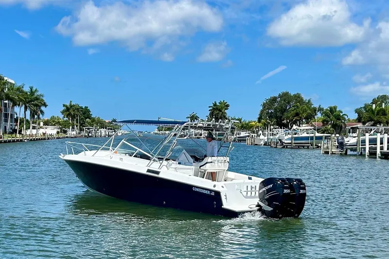 Slide: The Image of 2001 Contender 35 Side Console boat cruising on a sunny day in a scenic waterway. - 2