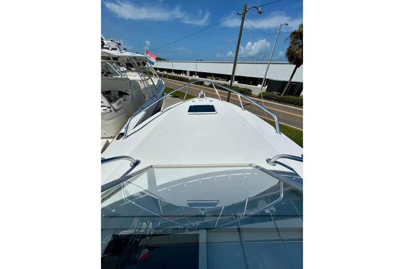Slide: The Image of 2001 Contender 35 Side Console boat, docked, with clear skies and nearby vessels. - 21