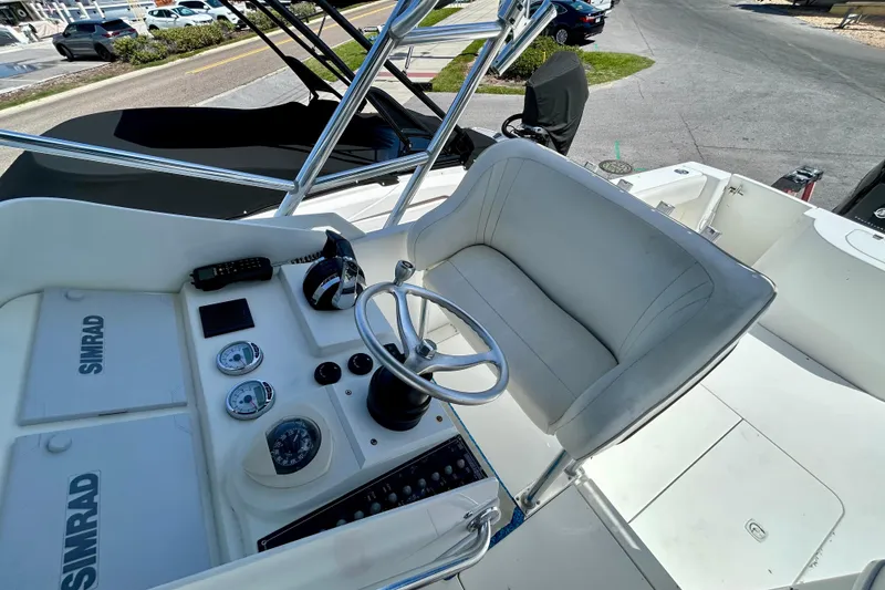 Slide: The Image of 2001 Contender 35 Side Console boat helm with steering wheel and Simrad electronics. - 23