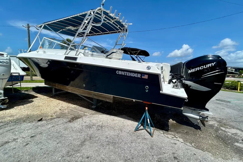 Slide: The Image of 2001 Contender 35 Side Console boat with Mercury engine on display outdoors. - 27