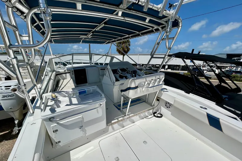Slide: The Image of 2001 Contender 35 Side Console boat interior with helm, seating, and canopy under blue sky. - 6