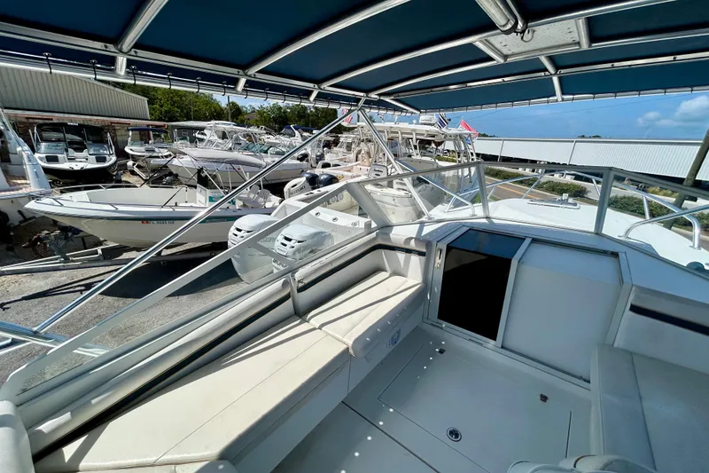 Slide: The Image of 2001 Contender 35 Side Console boat interior with seating and canopy, docked among other boats. - 9
