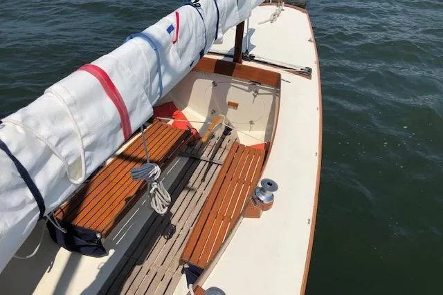 Slide: The Image of 1963 Cape Cod Shipbuilding Shields sailboat with wooden benches on calm water. - 31