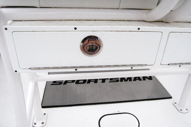 Slide: The Image of 2023 Sportsman Open 242 Center Console storage compartment with latch and branded mat. - 11