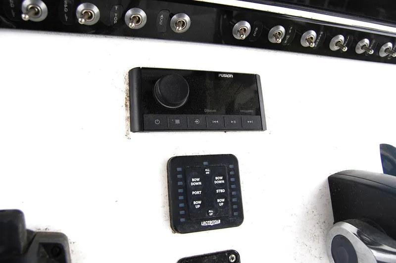 Slide: The Image of Control panel of 2023 Sportsman Open 242 Center Console boat with switches and audio system. - 6