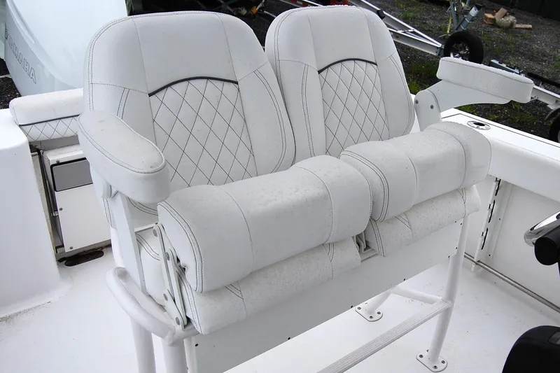 Slide: The Image of 2023 Sportsman Open 242 Center Console boat seats with white upholstery and armrests. - 8