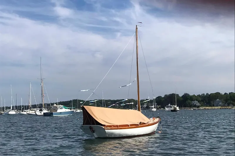 Slide: The Image of 1981 Edey & Duff Doughdish sailboat anchored in a scenic harbor with other boats. - 3