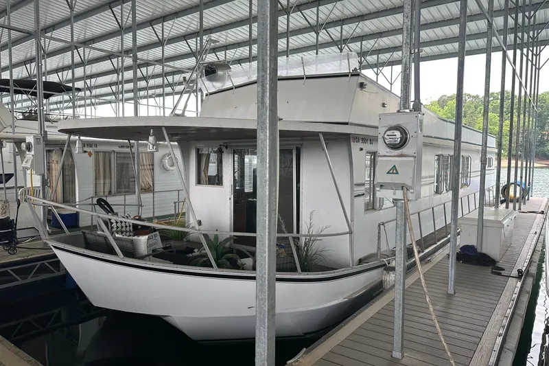 The Image of 1980 Lazy Days 14x59 houseboat docked in a covered marina. - 0