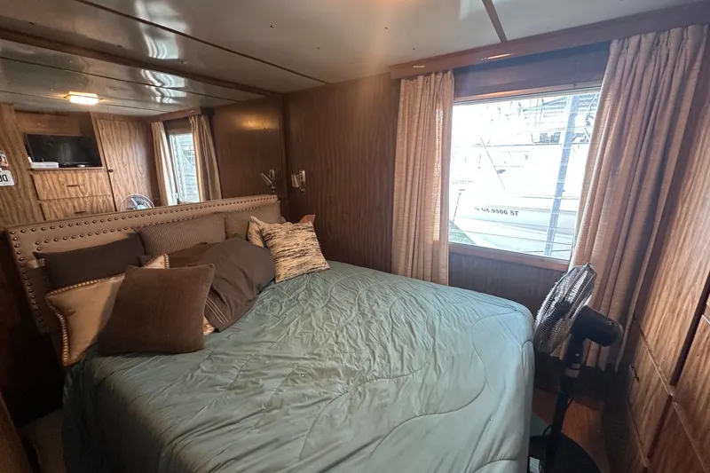 Slide: The Image of Cozy bedroom in 1980 Lazy Days 14x59 houseboat with wood paneling and large window. - 7
