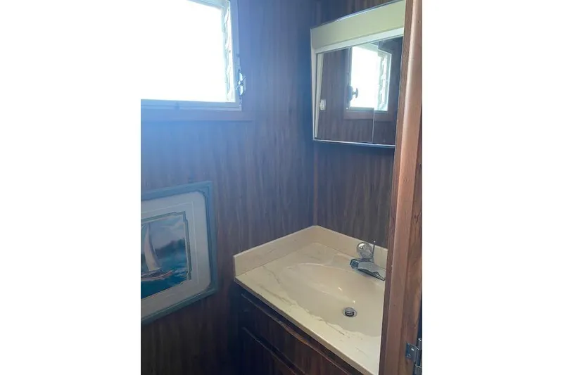 Slide: The Image of Small bathroom with wood paneling, mirror, and sink in a 1980 Lazy Days 14x59 model. - 8