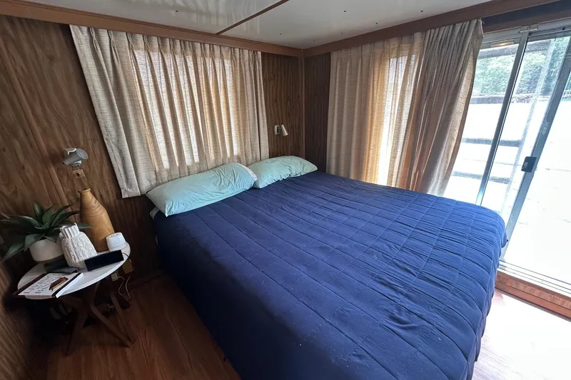 Slide: The Image of Cozy bedroom in 1980 Lazy Days 14x59 houseboat with blue bedding and wooden decor. - 9