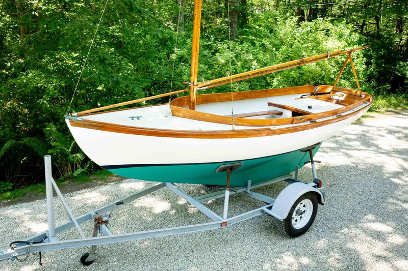 The Image of 1991 Edey & Duff Doughdish sailboat on trailer, surrounded by lush greenery. - 0