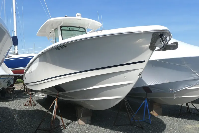 The Image of 2020 Boston Whaler 330 Outrage boat on stands, displayed outdoors. - 0