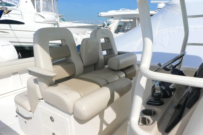 Slide: The Image of 2020 Boston Whaler 330 Outrage helm seating with beige cushions and steering console. - 10
