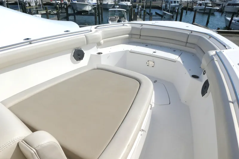 Slide: The Image of 2020 Boston Whaler 330 Outrage boat interior with cushioned seating and harbor view. - 11