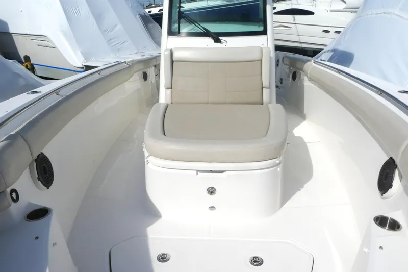 Slide: The Image of 2020 Boston Whaler 330 Outrage boat interior with cushioned seating and sleek design. - 12