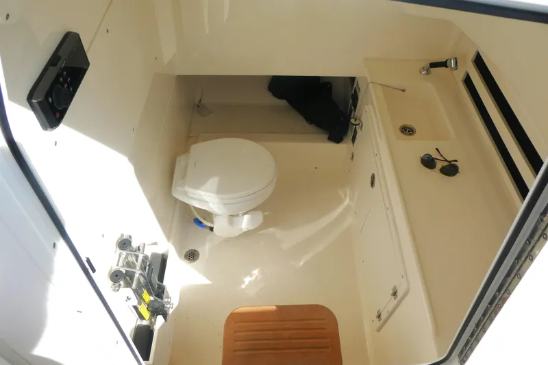 Slide: The Image of 2020 Boston Whaler 330 Outrage cabin interior with toilet and sink. - 14