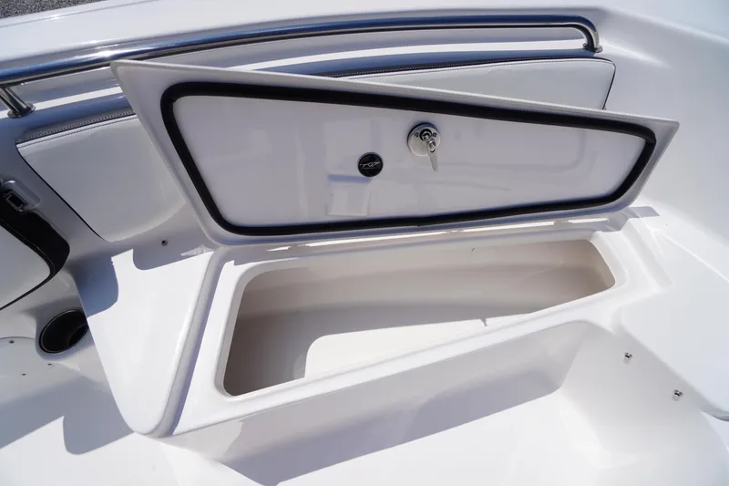 Slide: The Image of 2025 Tidewater 198 CC Adventure boat storage compartment with open lid and key lock. - 12