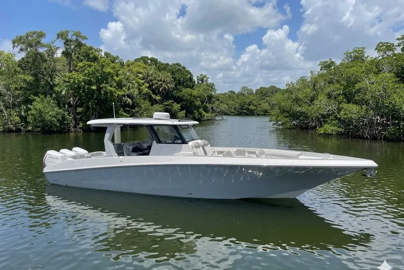 The Image of 2024 Fountain 38 SCX boat on a serene river, surrounded by lush greenery. - 0