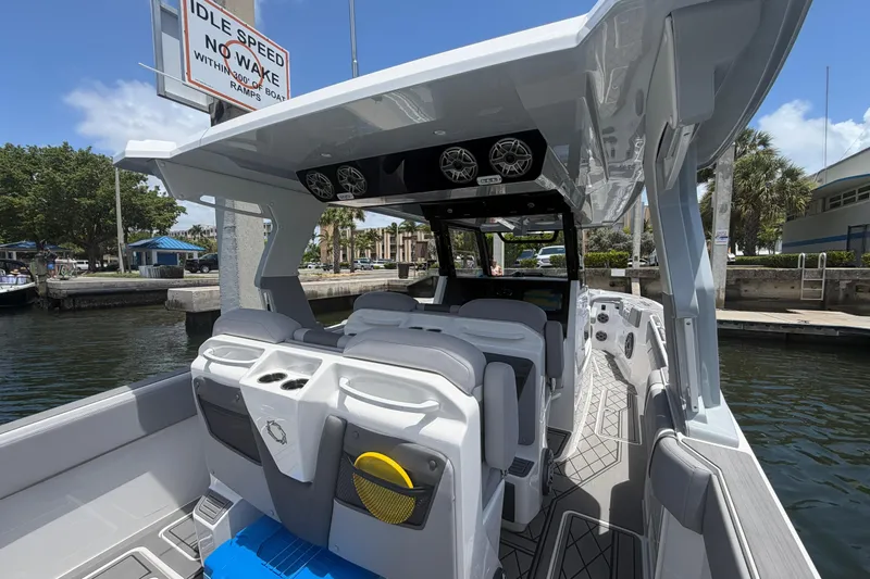 Slide: The Image of 2024 Fountain 38 SCX boat interior with modern seating and audio system at a marina. - 2