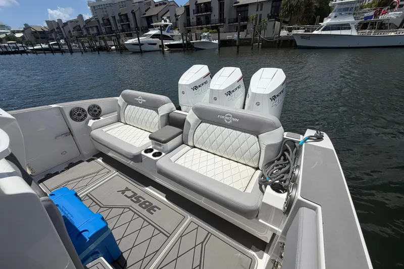 Slide: The Image of 2024 Fountain 38 SCX boat interior with cushioned seating and powerful outboard engines. - 21