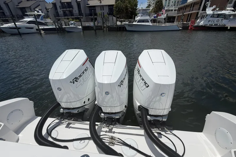 Slide: The Image of Triple outboard engines on a 2024 Fountain 38 SCX boat docked in a marina. - 22