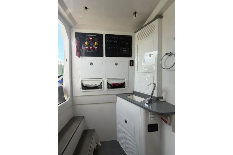 Slide: The Image of 2024 Fountain 38 SCX boat interior with control panel and compact kitchenette. - 26
