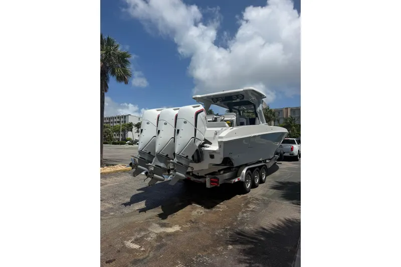 Slide: The Image of 2024 Fountain 38 SCX boat on trailer, featuring triple outboard engines under a clear blue sky. - 30