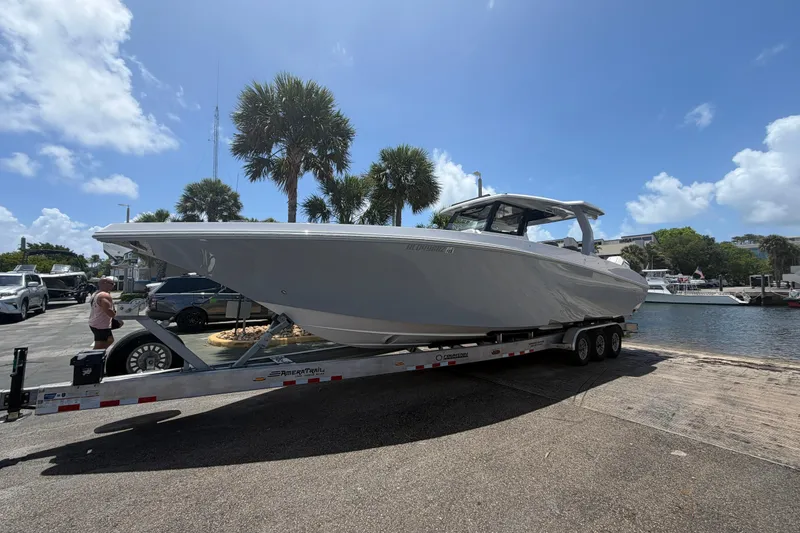 Slide: The Image of 2024 Fountain 38 SCX boat on trailer by waterfront, under clear blue sky. - 34