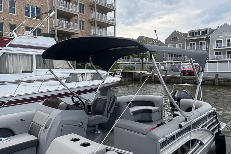 The Image of 2022 Bennington Saltwater Series pontoon boat docked near waterfront homes. - 0