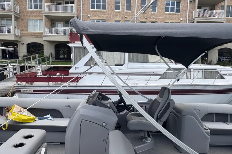 Slide: The Image of 2022 Bennington Saltwater Series boat docked near waterfront apartments. - 2