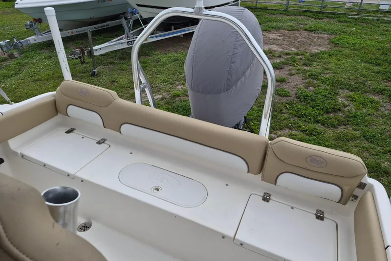 Slide: The Image of 2016 Key West 219 FS boat interior with beige seating and storage compartments. - 10