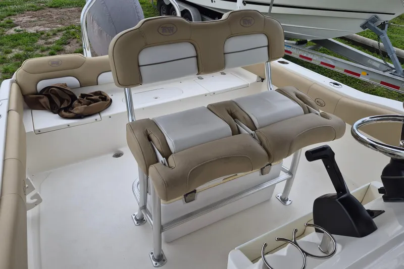 Slide: The Image of 2016 Key West 219 FS boat interior with beige seating and steering wheel. - 7
