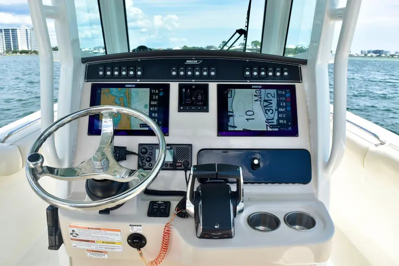 Slide: The Image of 2023 Boston Whaler 280 Outrage helm with navigation screens and steering wheel. - 11