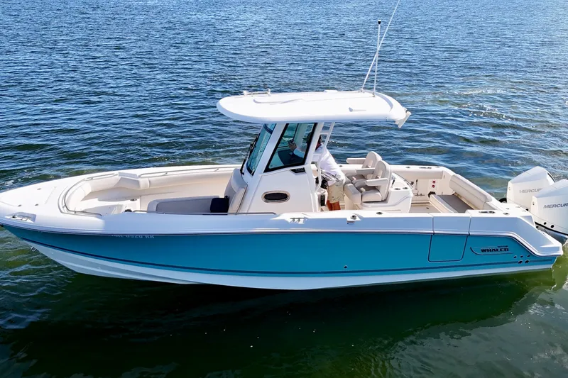 Slide: The Image of 2023 Boston Whaler 280 Outrage boat on water, featuring sleek design and vibrant blue hull. - 2