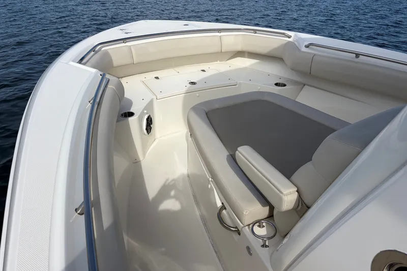 Slide: The Image of 2023 Boston Whaler 280 Outrage boat interior with cushioned seating and ocean backdrop. - 20