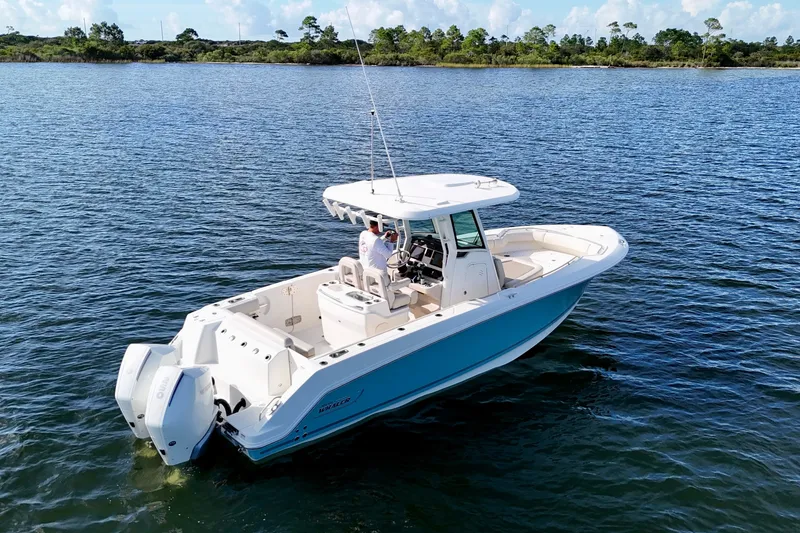 Slide: The Image of 2023 Boston Whaler 280 Outrage boat on calm water, featuring dual engines. - 11