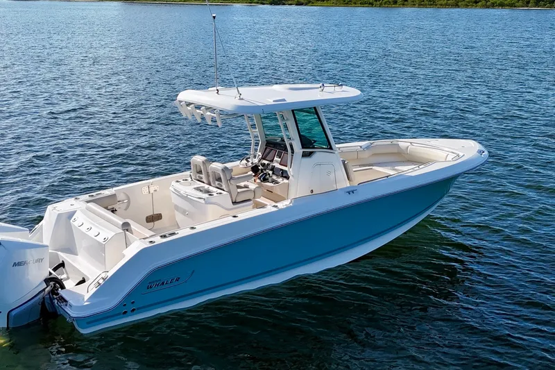 Slide: The Image of 2023 Boston Whaler 280 Outrage boat on calm water, showcasing sleek design and spacious deck. - 6