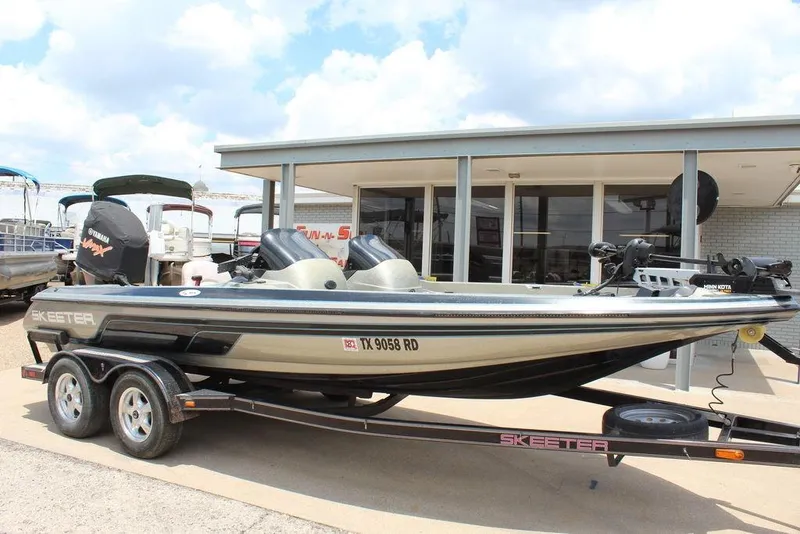 The Image of 2006 Skeeter SX200 boat on trailer, parked outside a building under a cloudy sky. - 1