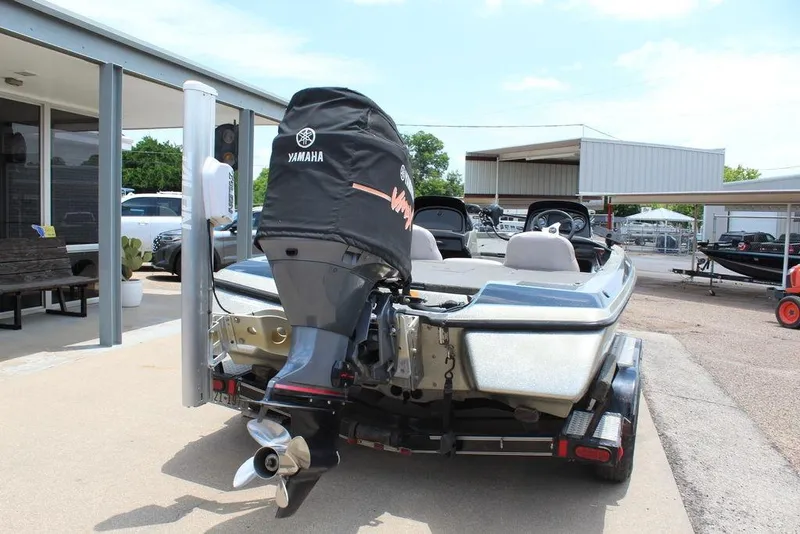 Slide: The Image of 2006 Skeeter SX200 boat with Yamaha outboard motor, parked on a trailer at a dealership. - 13
