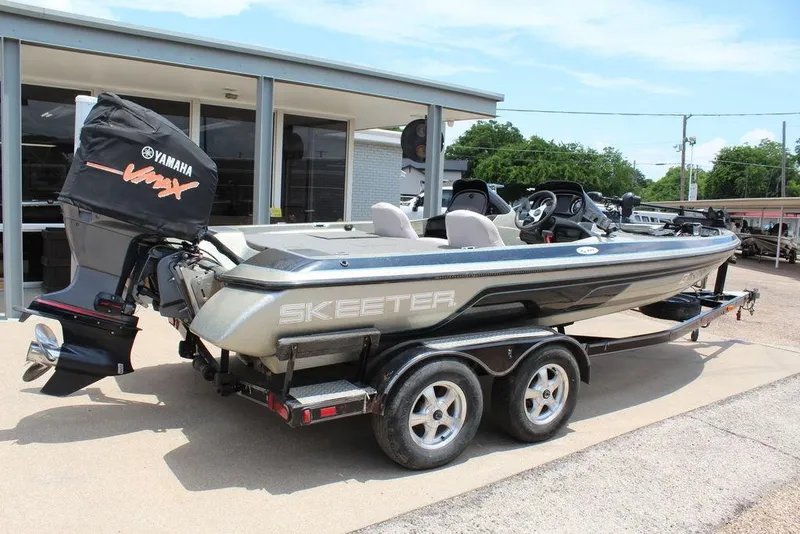 Slide: The Image of 2006 Skeeter SX200 boat with Yamaha engine, parked on a trailer outside a building. - 3