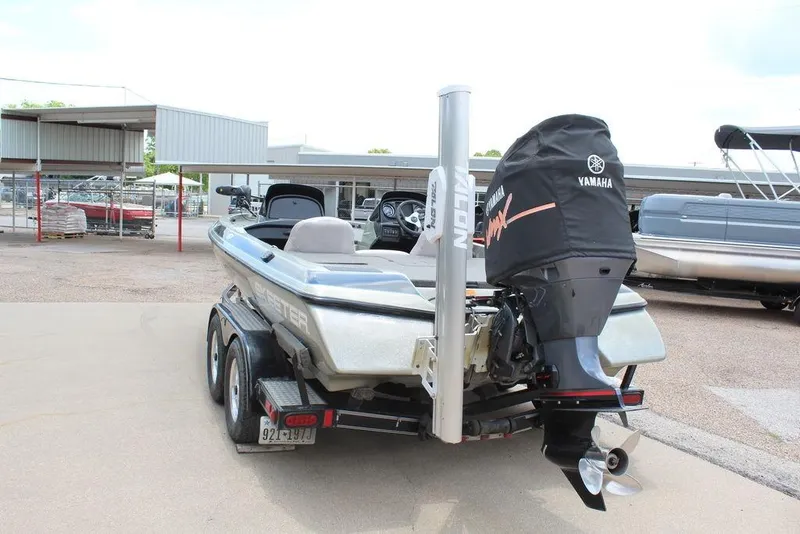 Slide: The Image of 2006 Skeeter SX200 boat with Yamaha motor, parked on a trailer at a marina. - 6