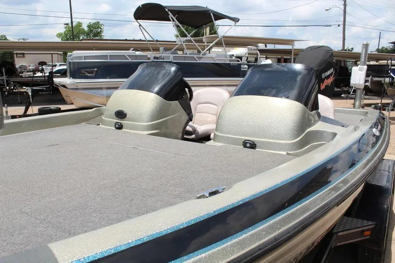 Slide: The Image of 2006 Skeeter SX200 boat with Yamaha engine, parked in a marina under a cloudy sky. - 7