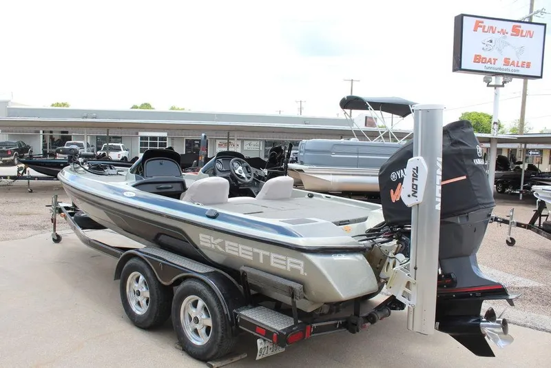 Slide: The Image of 2006 Skeeter SX200 boat at dealership, featuring Yamaha engine and dual-axle trailer. - 9