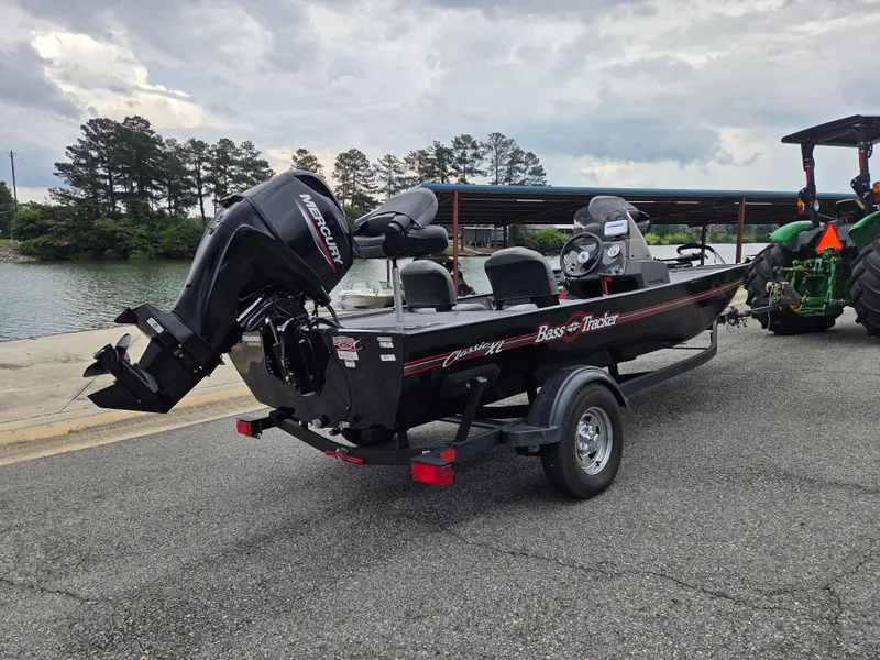 Slide: The Image of 2024 Tracker Bass Tracker Classic XL boat by the water. - 4