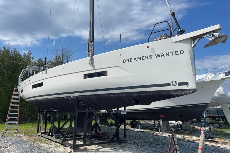 The Image of 2022 Dufour 530 sailboat on dry dock with "Dreamers Wanted" text. - 0
