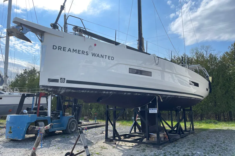 Slide: The Image of 2022 Dufour 530 sailboat on stands, "Dreamers Wanted" text, under a partly cloudy sky. - 15