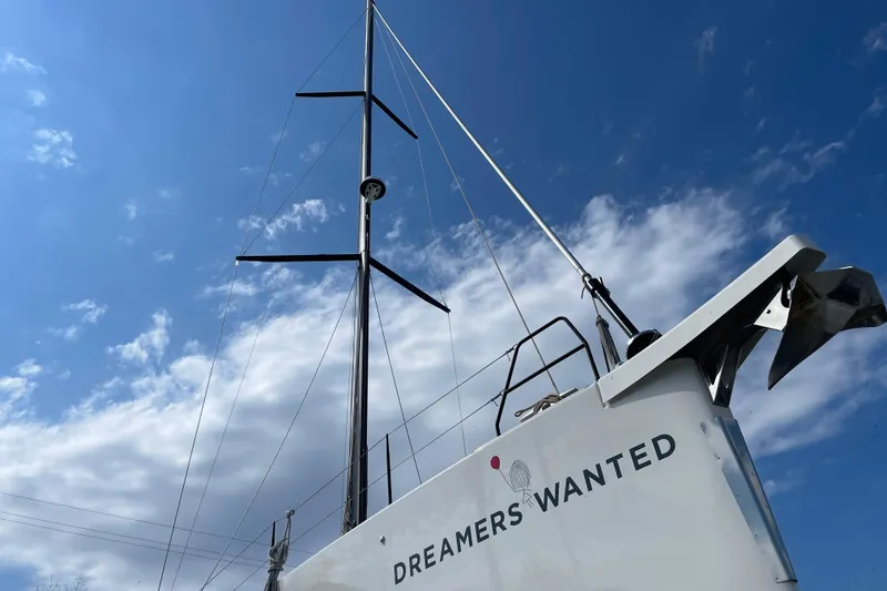 Slide: The Image of Dufour 530 sailboat, 2022 model, with "Dreamers Wanted" text, under a blue sky. - 16